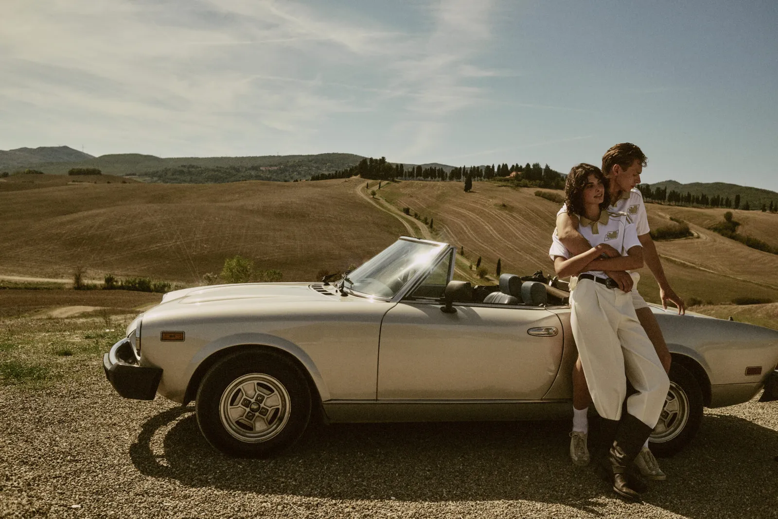The third kit, a couple and a vintage convertible in the Tuscan hills